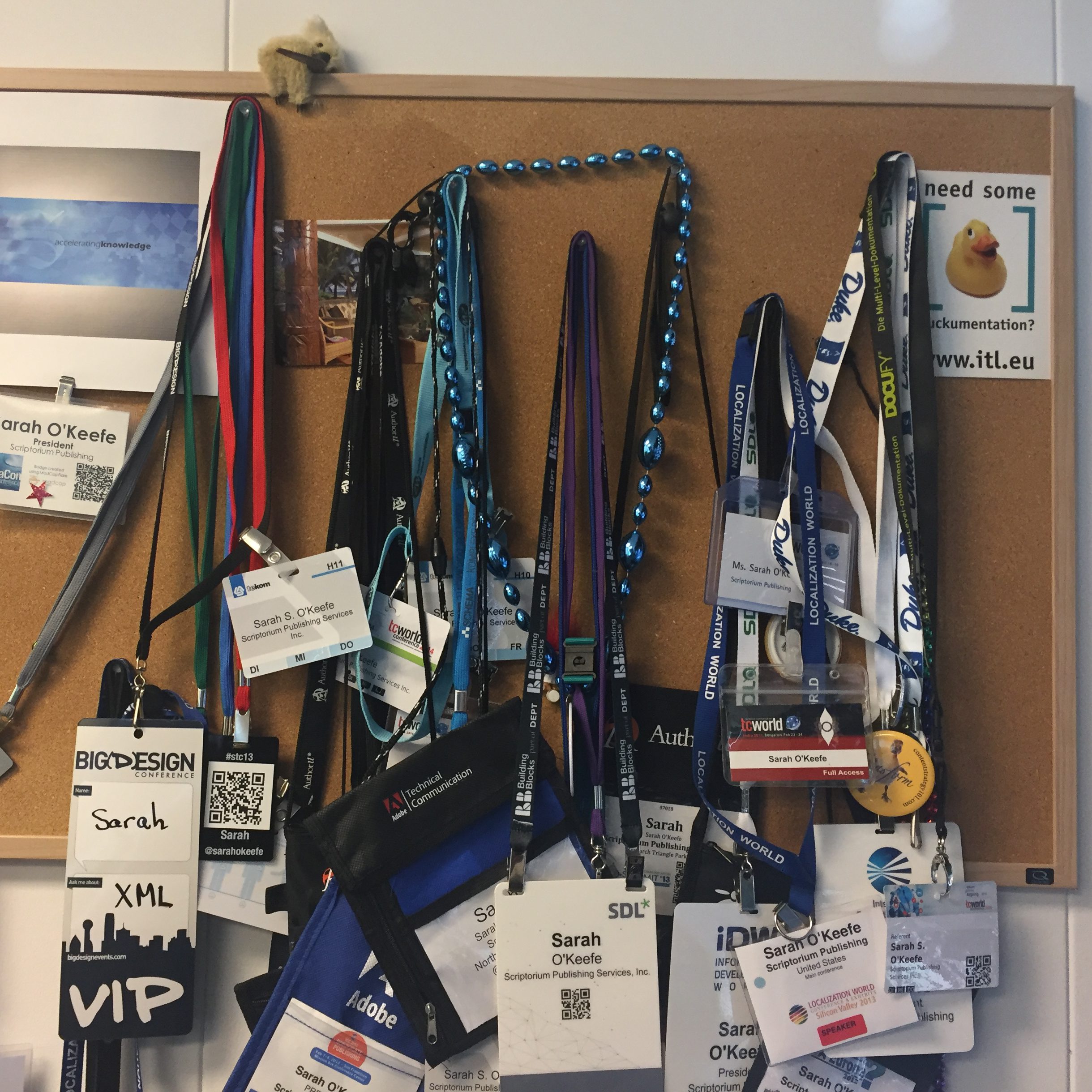 Sarah's collection of conference badges hanging from a corkboard